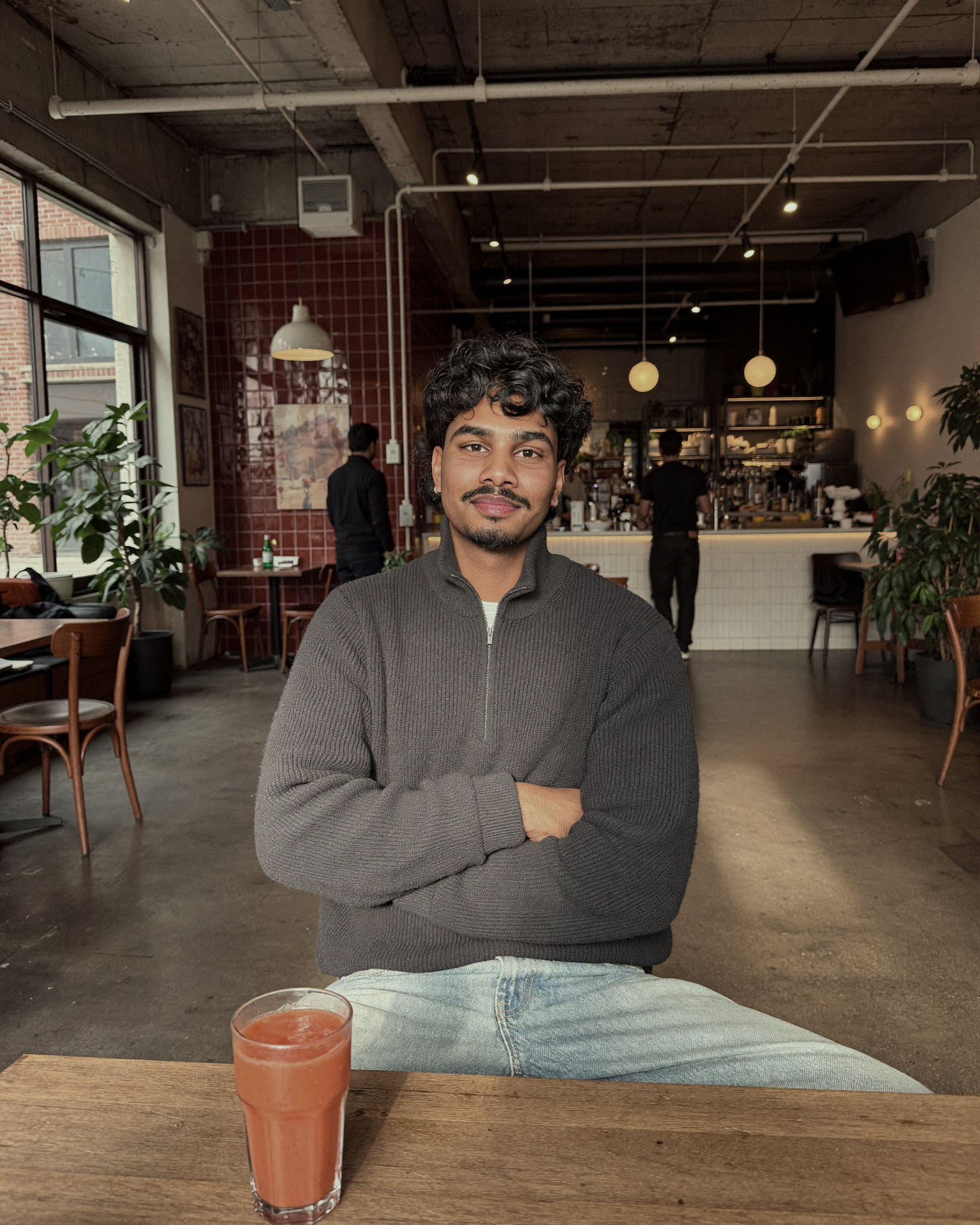 Nadil, co-founder, portrait against a curtain backdrop