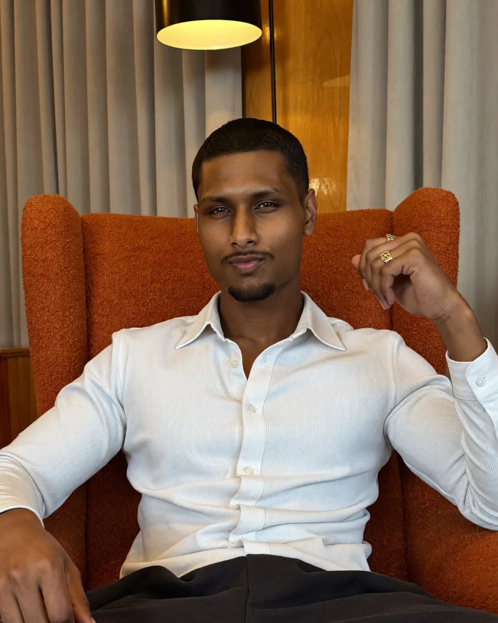 Shaq, co-founder, portrait in an armchair under warm light